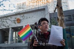 Yang Teng gay dari Beijing memegang bendera homo, patung Lady Justice dan hasil pengadilan